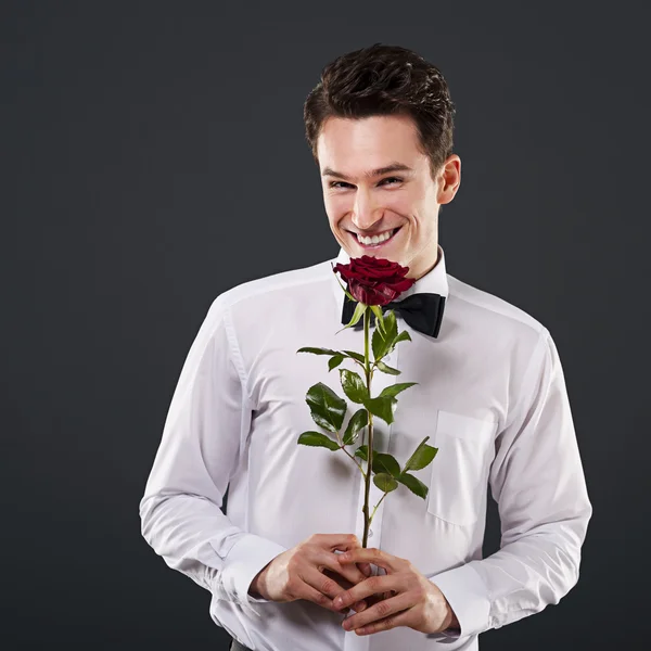 Uomo sorridente con rosa rossa — Foto Stock