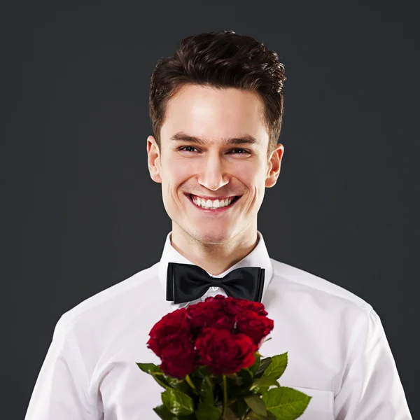 Homem bonito com rosas vermelhas — Fotografia de Stock