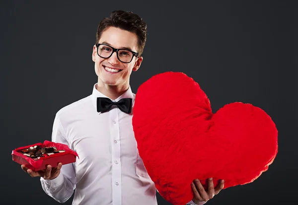 Man holding heart shape and box of chocolate — Stock Photo, Image