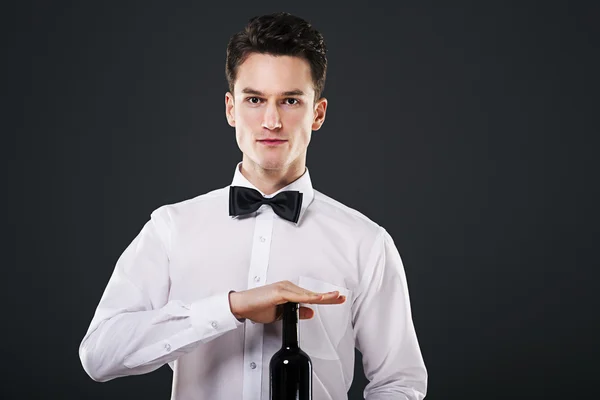 Waiter holding a bottle of wine — Stock Photo, Image