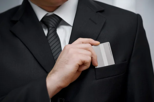Empresario poniendo su tarjeta de crédito en el bolsillo — Foto de Stock