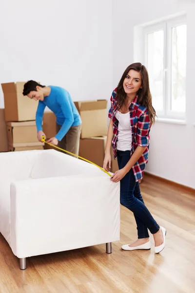 Young couple measuring the sofa — Stock Photo, Image