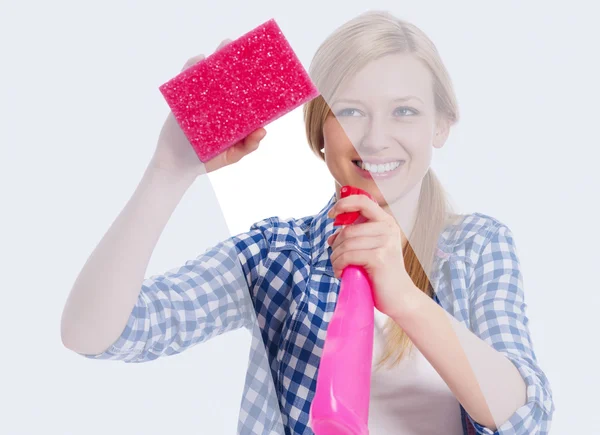 Young woman standing behind window and washing it — Stock Photo, Image