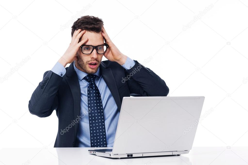 Shocked businessman looking at laptop