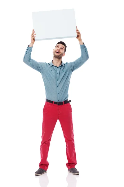 Happy man holding a blank sign overhead — Stock Photo, Image