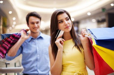 kredi kartı ve alışveriş torbaları tutan odak genç kadın