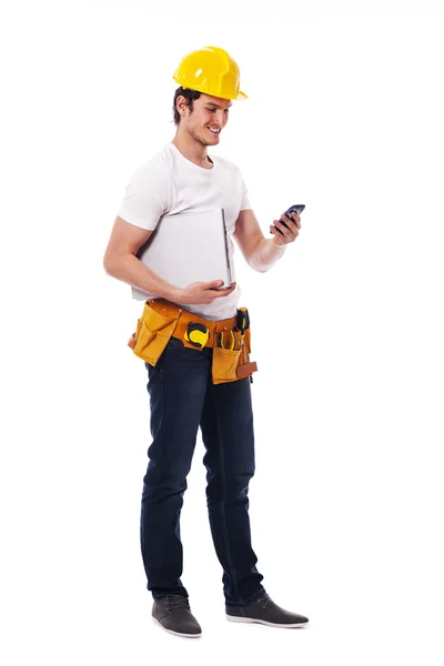 建設労働者が携帯電話上で何かをチェックします。 — ストック写真