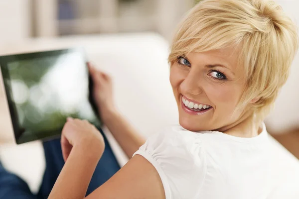 Χαμογελαστή γυναίκα χρησιμοποιώντας ψηφιακή δισκίο στο σπίτι — Φωτογραφία Αρχείου