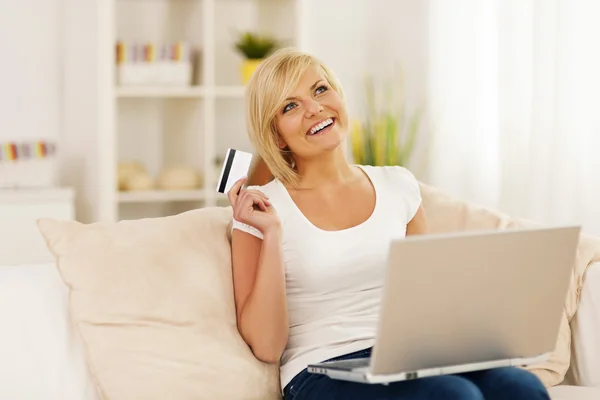 Uśmiechnięta młoda kobieta za pomocą laptopa i posiadania karty kredytowej Zdjęcia Stockowe bez tantiem