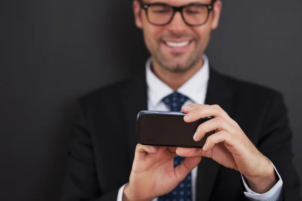 Empresario mensajes de texto en el teléfono inteligente — Foto de Stock