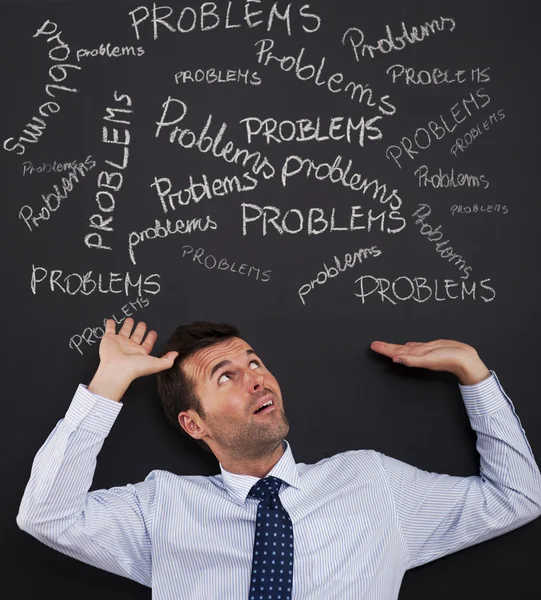 Businessman bending under stack of problems — Stock Photo, Image