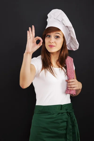 Unga kvinnliga matlagning kock visar ok tecken — Stockfoto