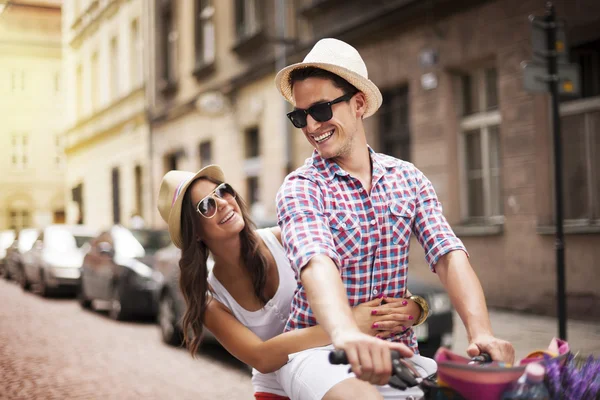 Bonito homem levando sua namorada no rack de bicicleta — Fotografia de Stock