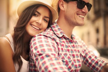 Close up of loving couple riding on bike in the city clipart