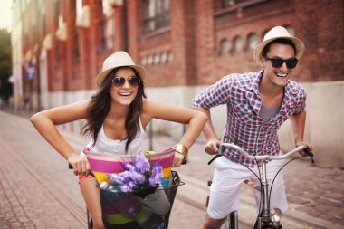 Couple riding bicycles in the city clipart