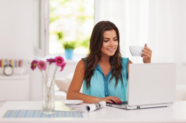 Evde bilgisayarını kullanan bir kadın.