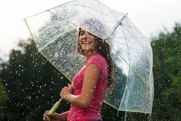 Young woman standing in summer rain with umbrella — Stock Photo, Image