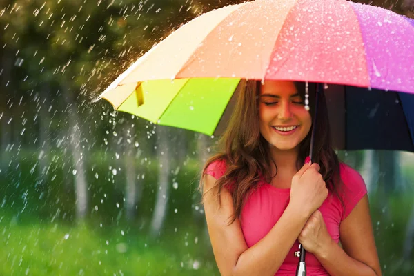 Mujer hermosa bajo el paraguas del arco iris — Foto de Stock