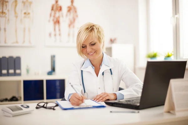 Female doctor working at her office — Stock Photo, Image