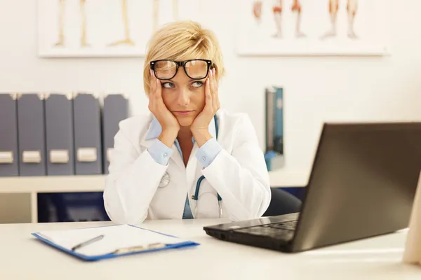 Médica mulher sentada em seu escritório — Fotografia de Stock