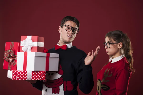 Rude nerdy man with christmas gifts — Stock Photo, Image