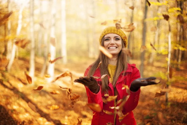 Mulher feliz jogando folhas — Fotografia de Stock