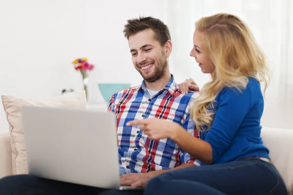 Casal feliz usando computador em casa — Fotografia de Stock