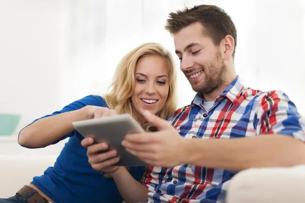 Lachende paar digitale Tablet PC thuis gebruiken — Stockfoto