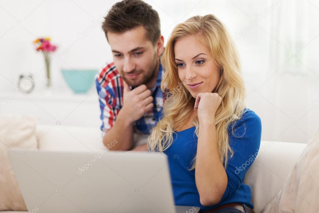 Young couple watching something on computer