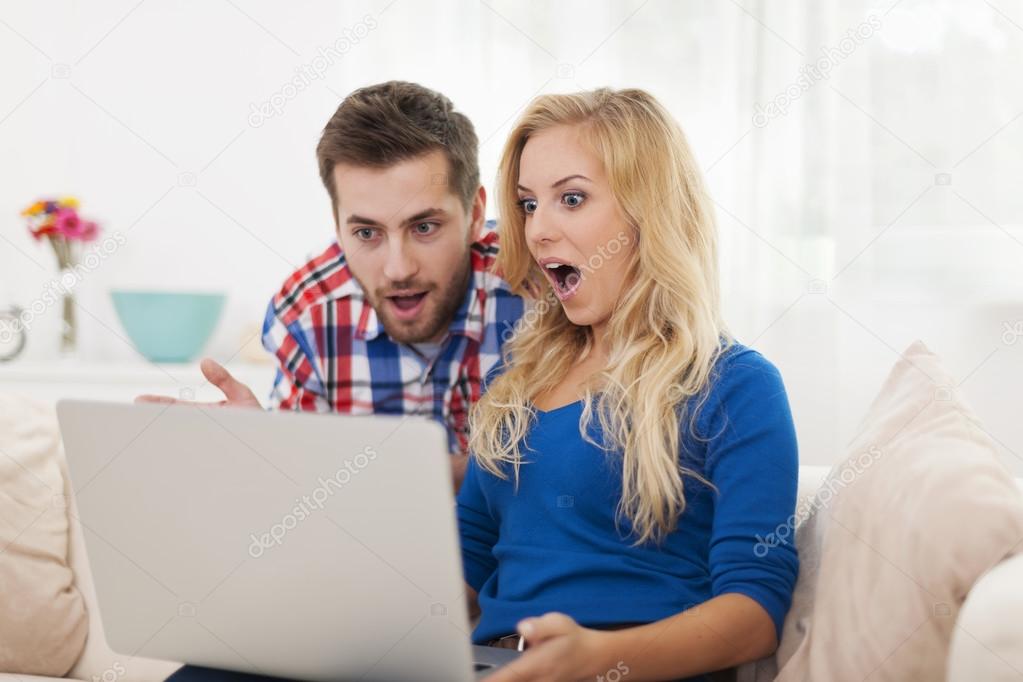 Shocked couple looking laptop