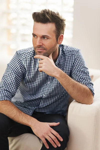 Przystojny mężczyzna siedzi na kanapie — Zdjęcie stockowe