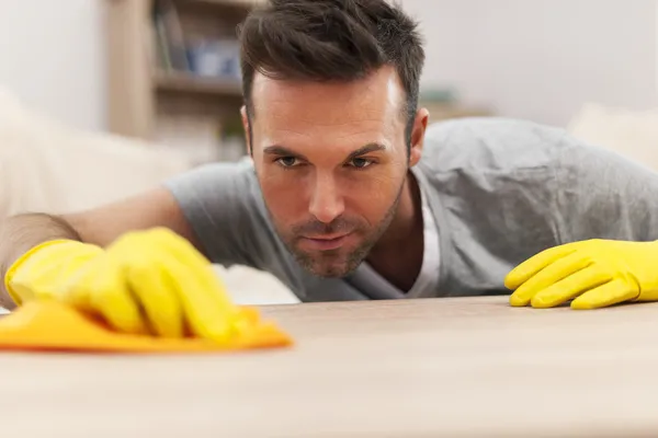 Un bel homme nettoie les taches de la table — Photo