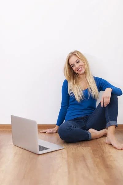 Frau sitzt auf Hartholzboden — Stockfoto