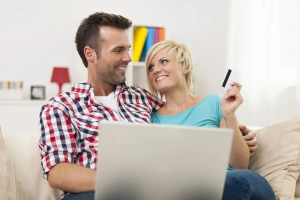 Casal com laptop e cartão de crédito — Fotografia de Stock