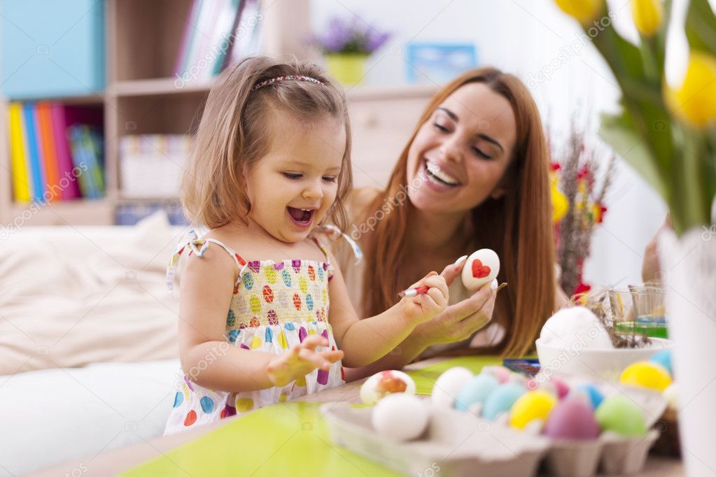 Mother and her baby painting easter eggs