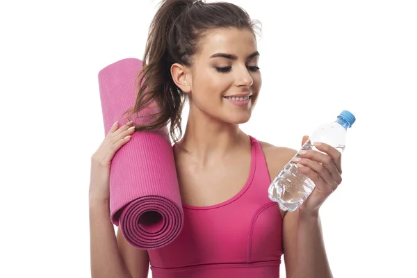 Mujer con agua y colchoneta de ejercicio — Foto de Stock