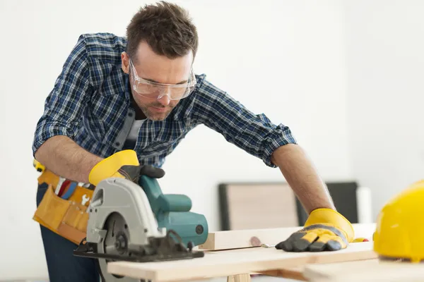 Carpenter sawing wood board — Stock Photo, Image