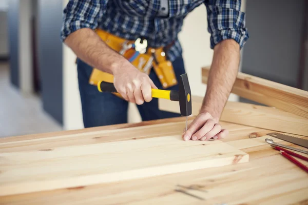 Mann schlägt Nagel mit Hammer — Stockfoto