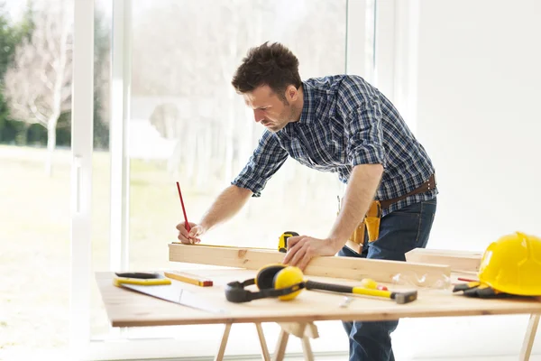 Homme mesurant des planches en bois — Photo