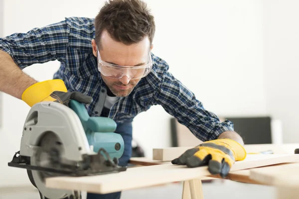 Carpenter cutting wooden plank — Stock Photo, Image