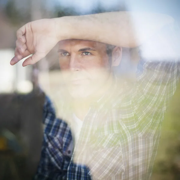 Hombre mirando por la ventana — Foto de Stock