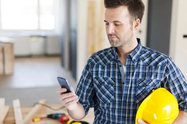 Trabajador de la construcción con teléfono móvil — Foto de Stock