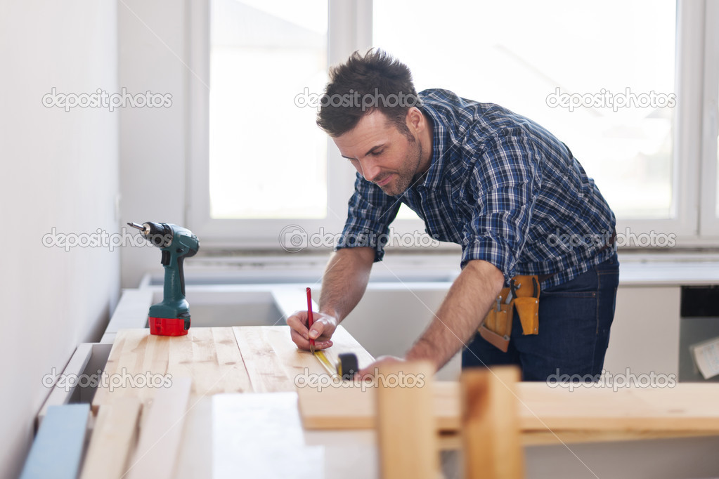 Carpenter measuring wooden planks