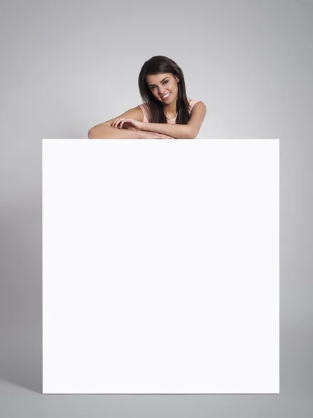 Woman leaning on empty whiteboard — Stock Photo, Image