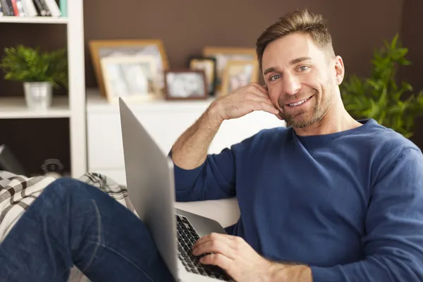 Uomo con computer portatile sul divano — Foto Stock