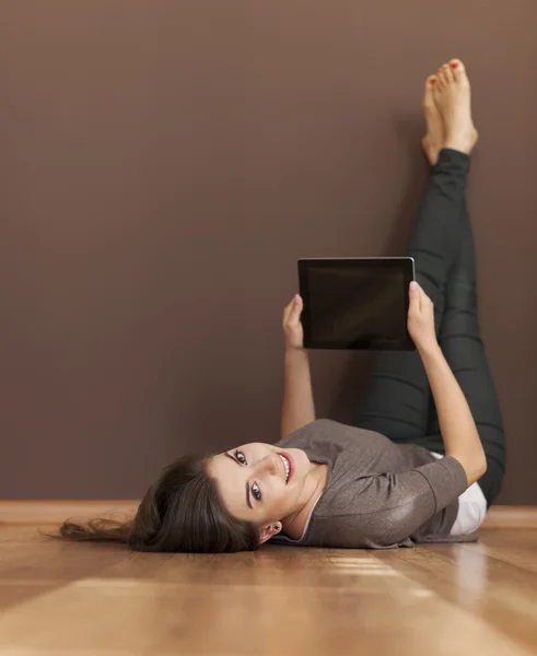 Žena leží na podlaze s digitálním tabletu — Stock fotografie