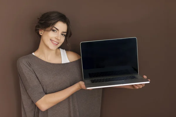 Mulher apresentando laptop contemporâneo — Fotografia de Stock