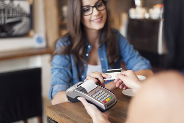 Smiling woman paying for coffee