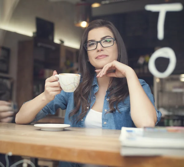 Kvinna dricker kaffe på café — Stockfoto