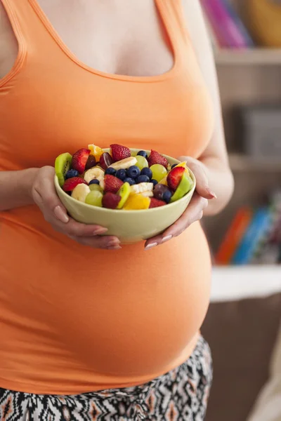 Těhotná žena s ovocným salátem — Stock fotografie
